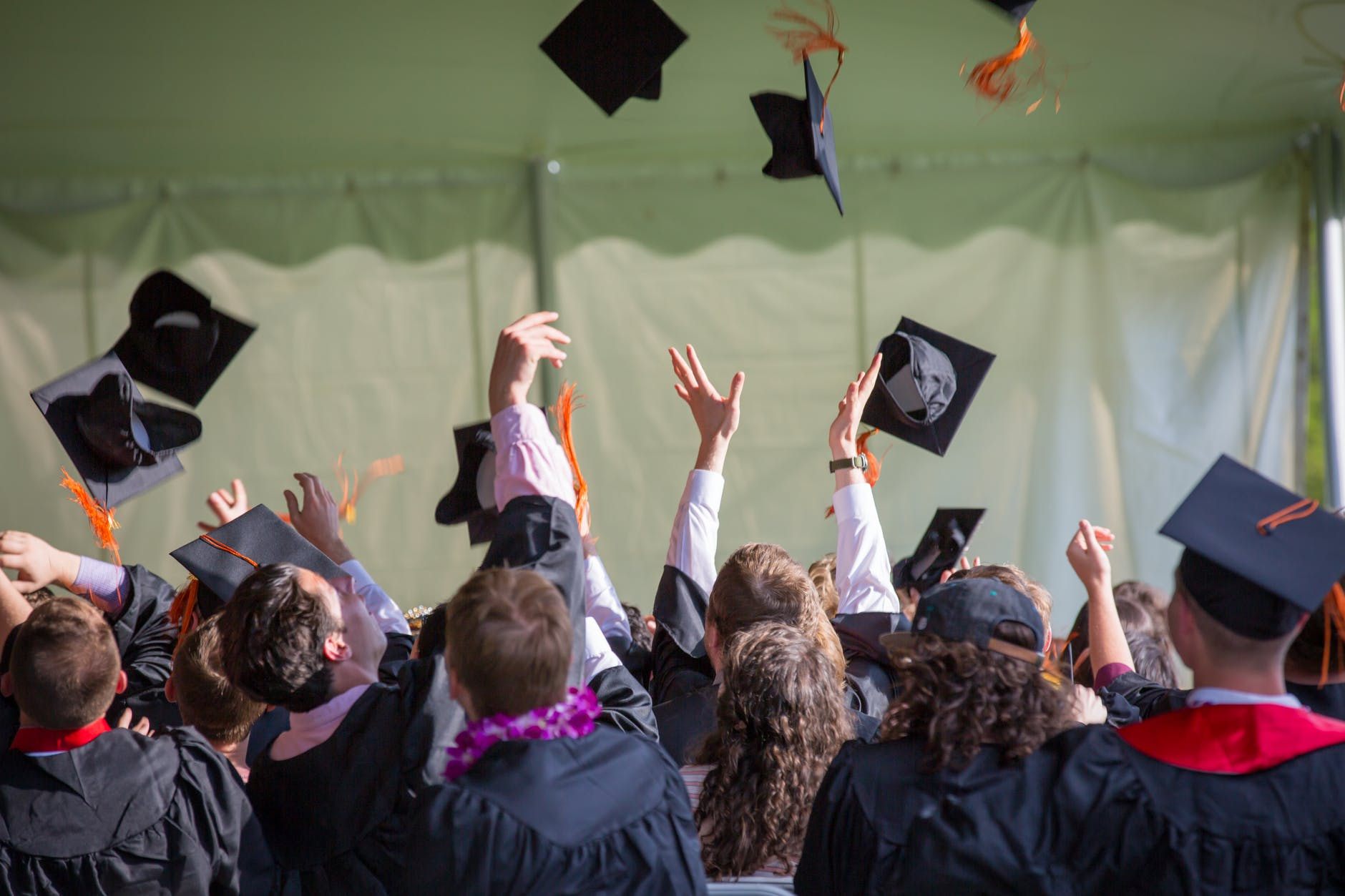 studenci rzucający czapkami na koniec roku akademickiego
