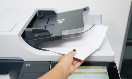 Kobieta w biurze wyciąga kartki z drukarki która została wypożyczona